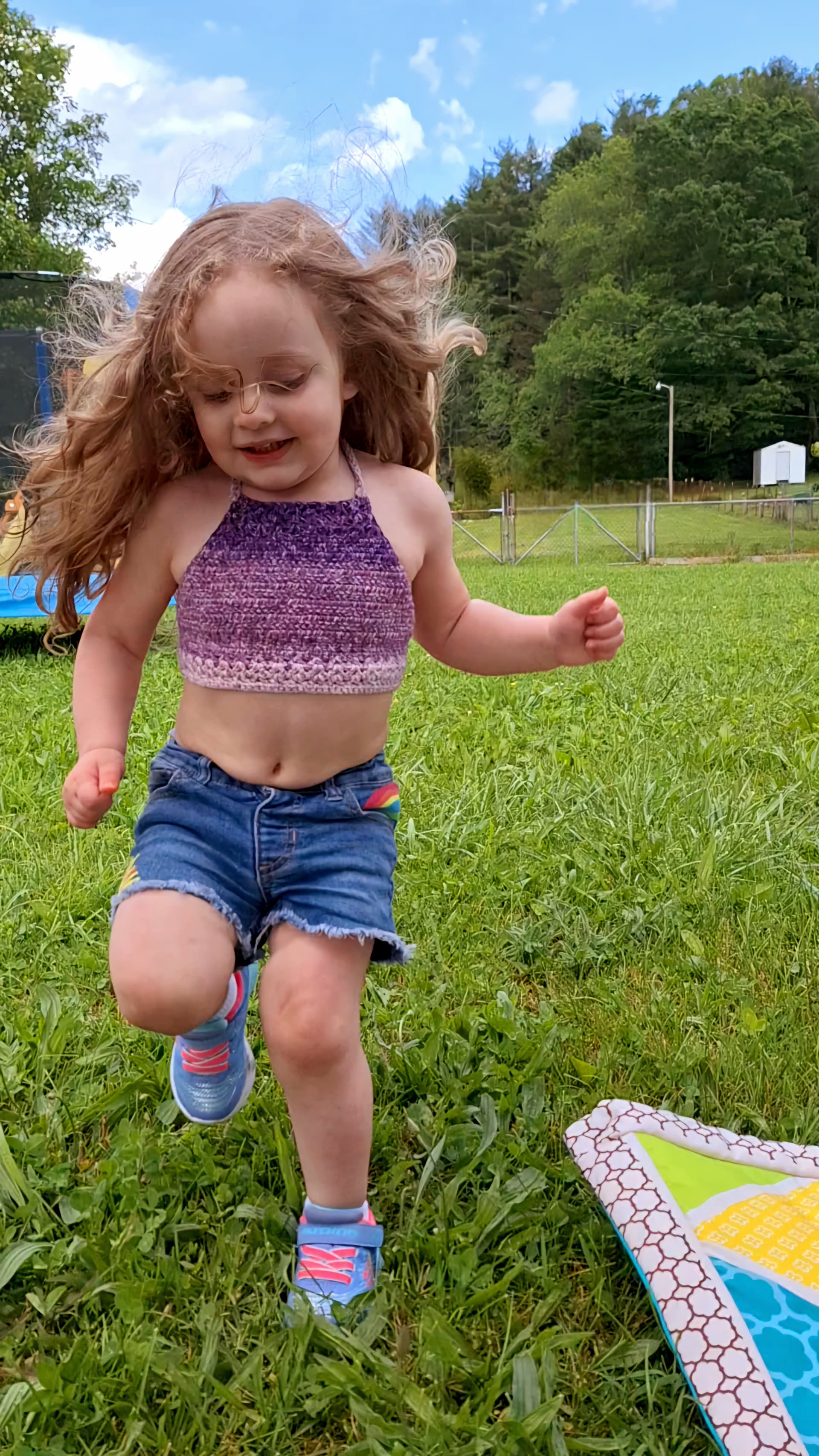 Happy cute toodler wearing Crocheted Hanna Algarve top in purple